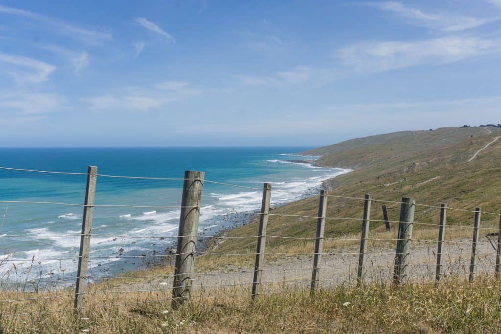 Wooden fence with brown hills and sea