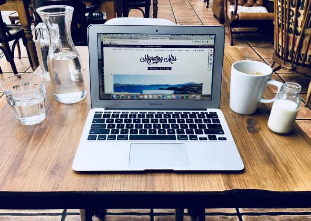 How to Find your Blogging Niche - Laptop on table with coffee and water