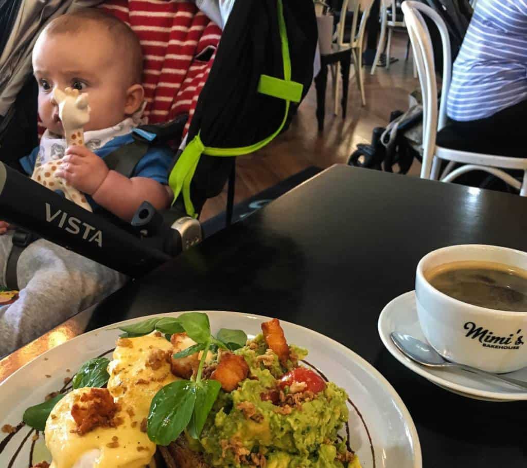 Baby Friendly Edinburgh Cafe: Baby in pram by table with Eggs and avocado brunch with black coffee