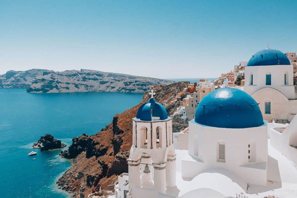 Babymoon Destinations Europe-Santorini - Blue and white buildings on cliff overlooking ocean