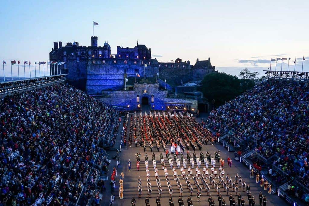 Edinburgh Military Tattoo - Scotland Flag on Edinburgh Castle and Military Bands and Dancers in lines on forecourt