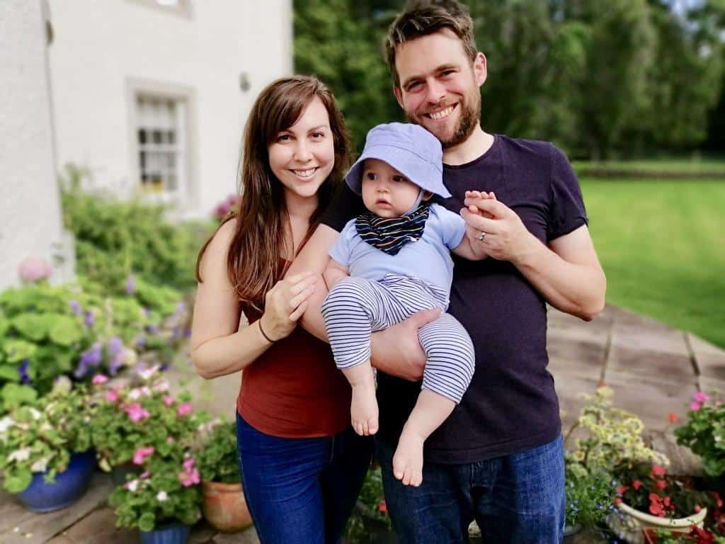 Family mum dad and baby in garden of house