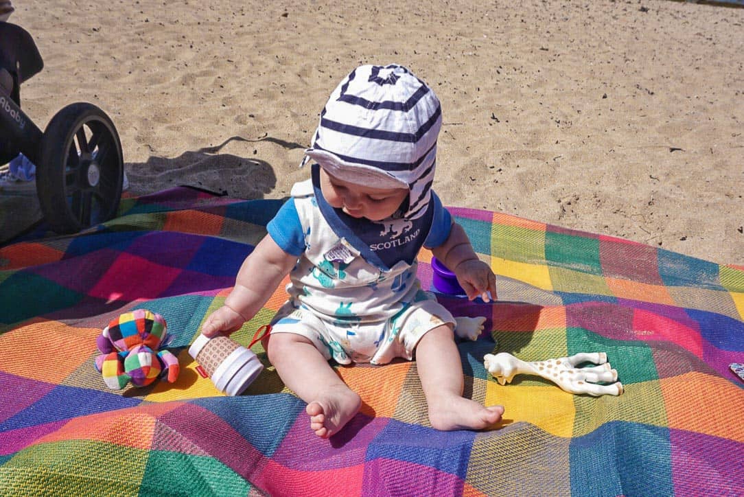 Baby on mat at the beach