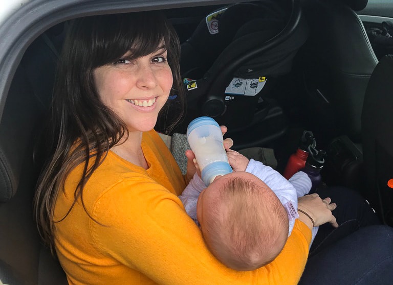 Feeding baby in car on road trip with baby