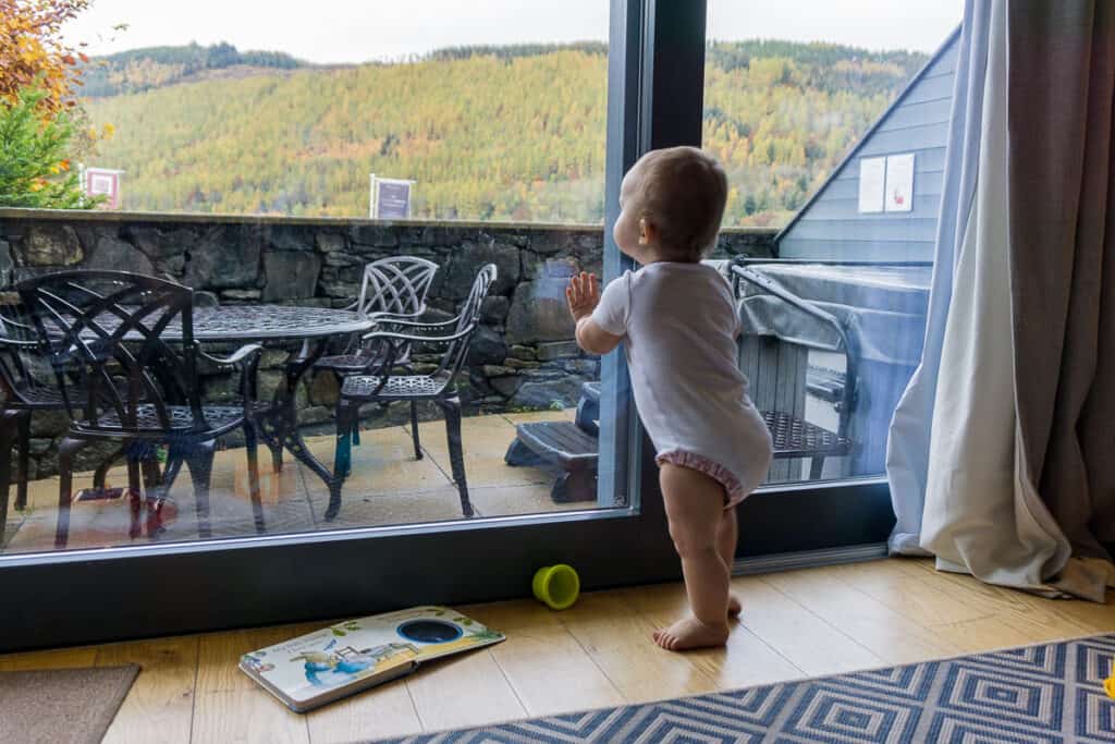 Baby looking out window at Taymouth Marina apartment