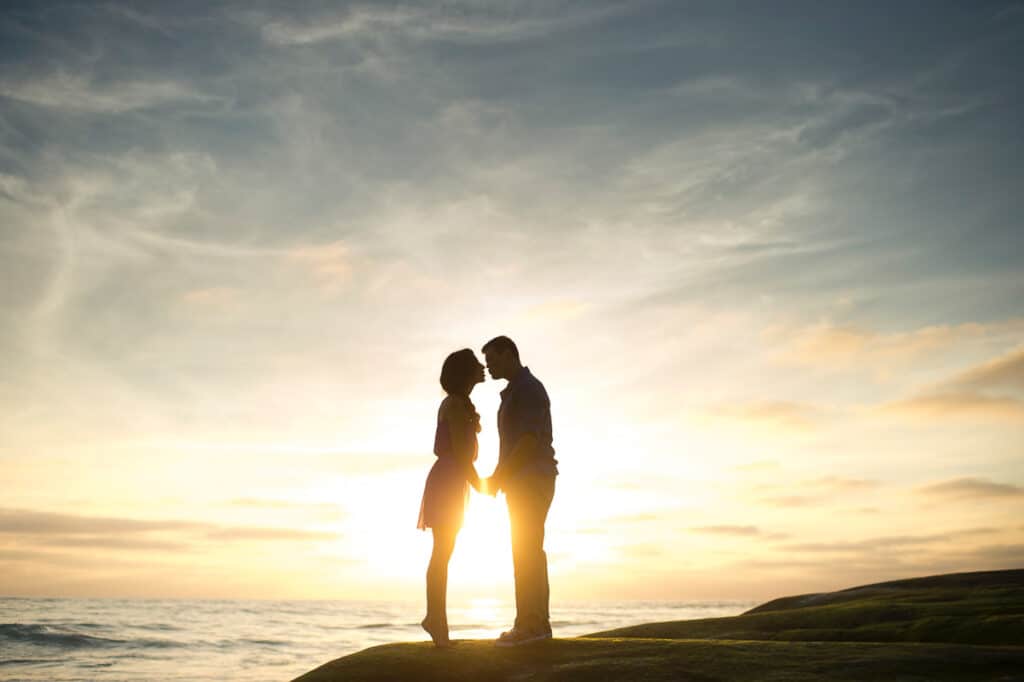 Romantic Places in the USA - Couple on rock kissing at sunset