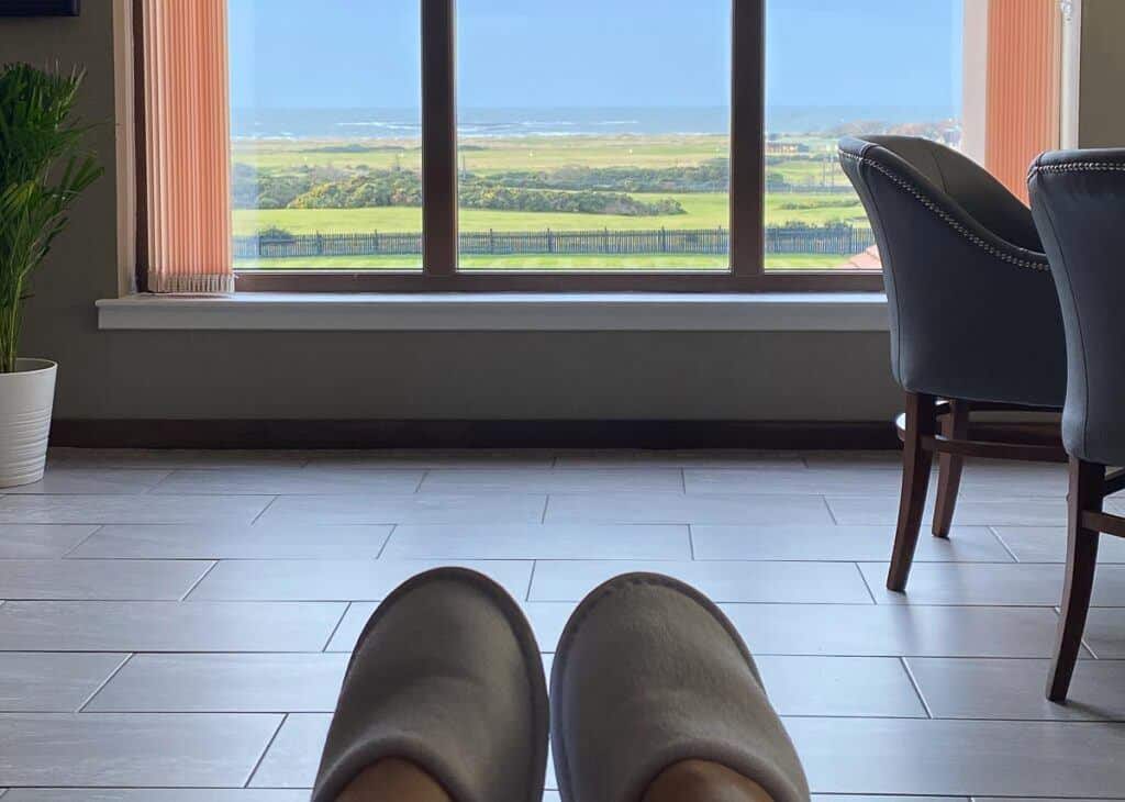 Feet in slippers in spa lounge looking out window