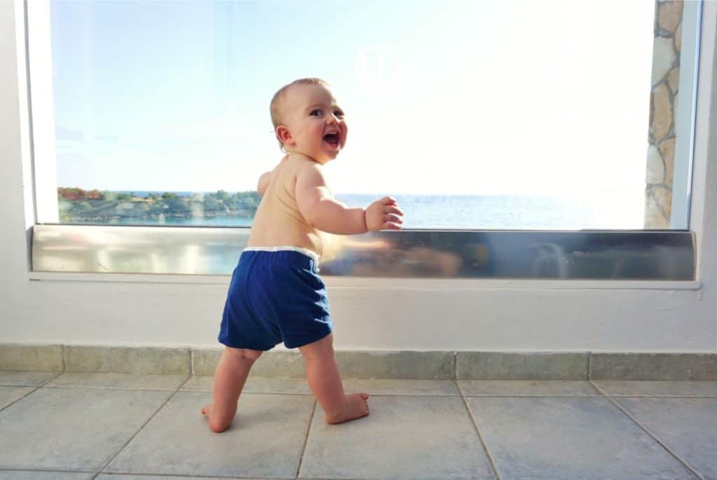 Best Greek Islands for Families - Baby on hotel balcony looking out at sea