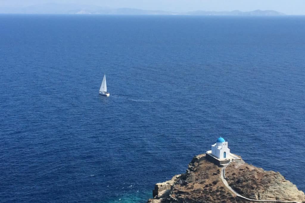 Best Greek Islands for Families - Church and sea with sailboat in Sifnos