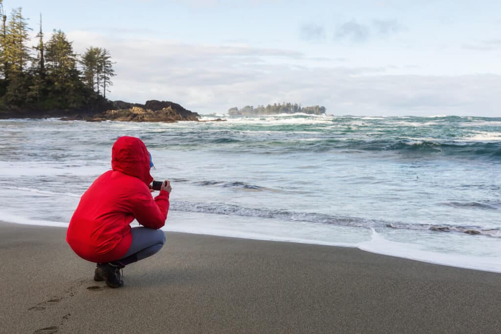 Things to do in Tofino, Vancouver Island - woman on the beach taking a photo